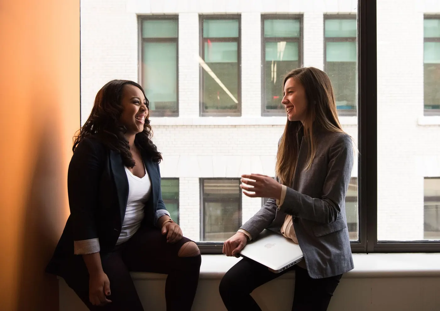 Two colleagues in conversation by a window