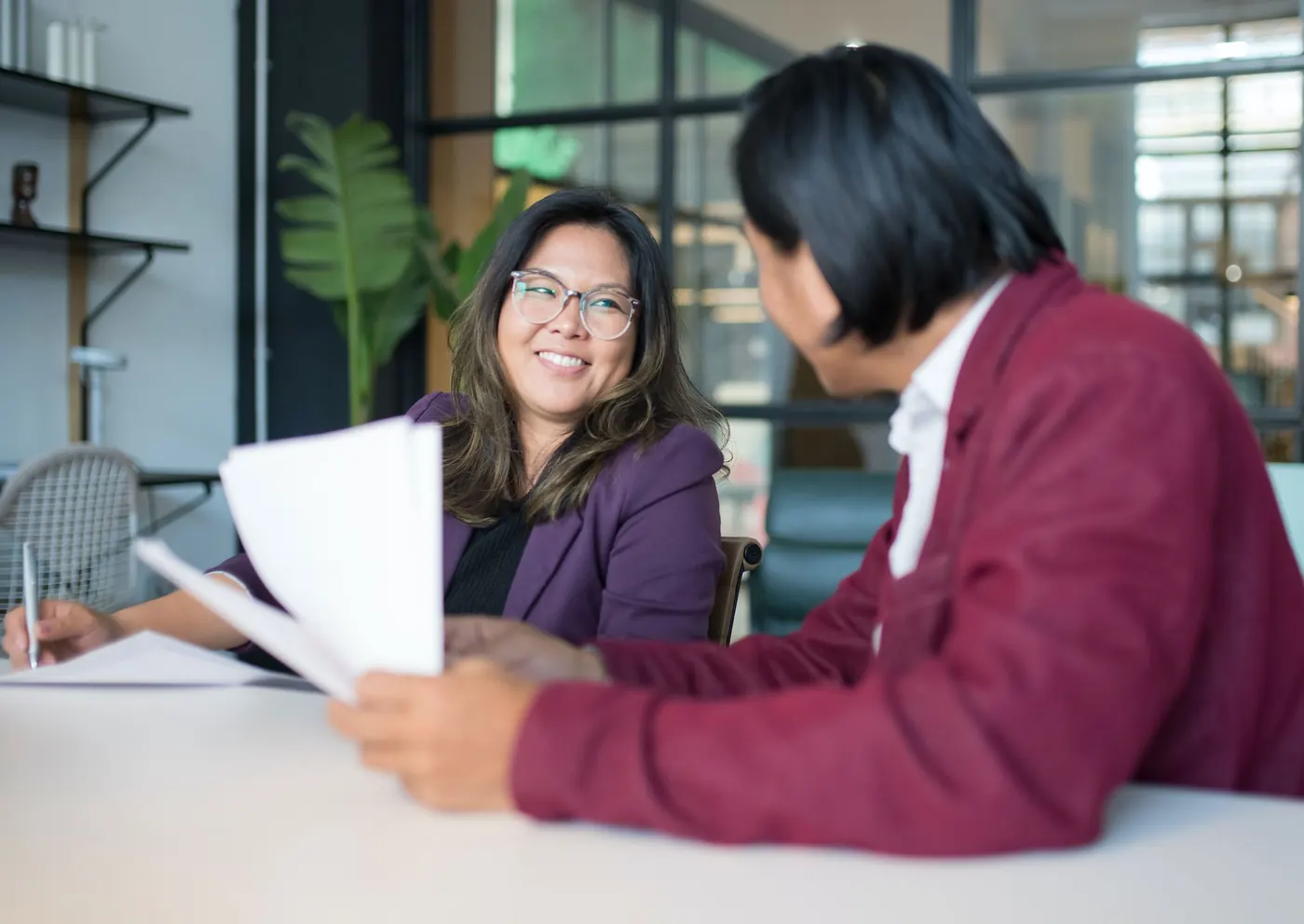 A manager and staff member reviewing documents together